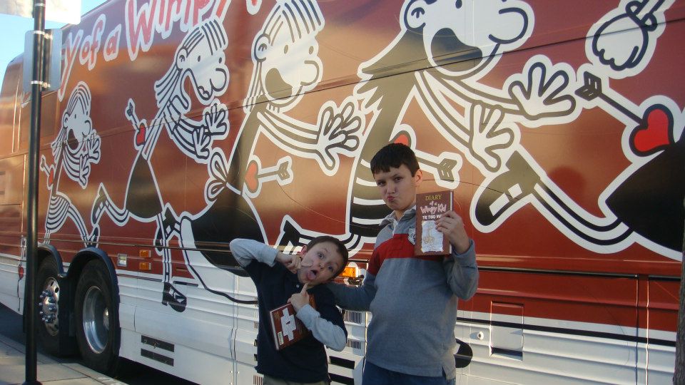 My boys posing with Jeff Kinney's tour bus. Kinney visited Blue Manatee Children's Bookstore in 20012.